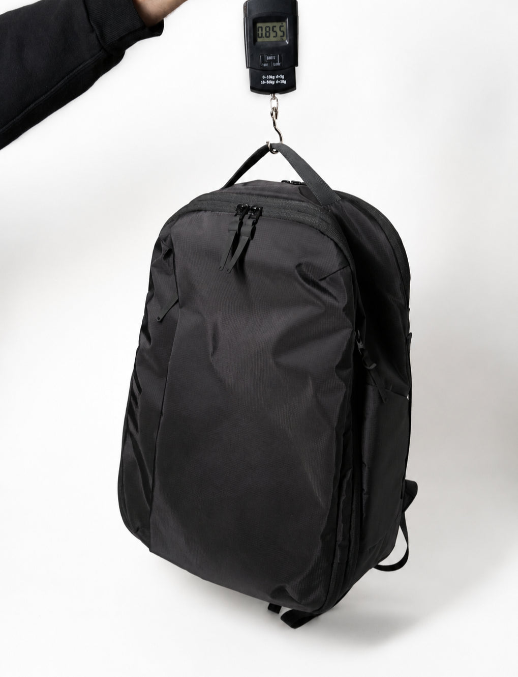 Almond Oak backpack hanging from a digital luggage scale